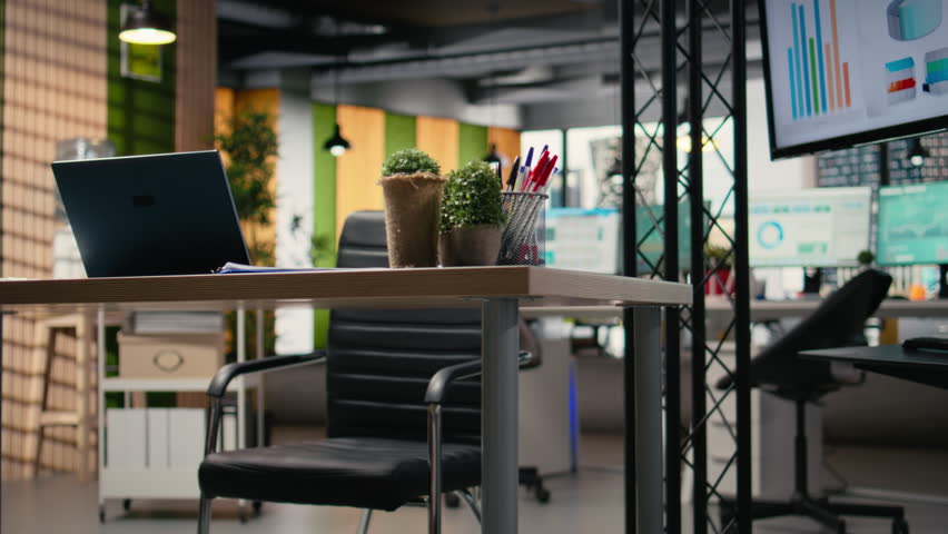 Empty office space offers environment for business management and planning in a corporate setting, forecasting tools, computers and performance charts support strategic objectives.