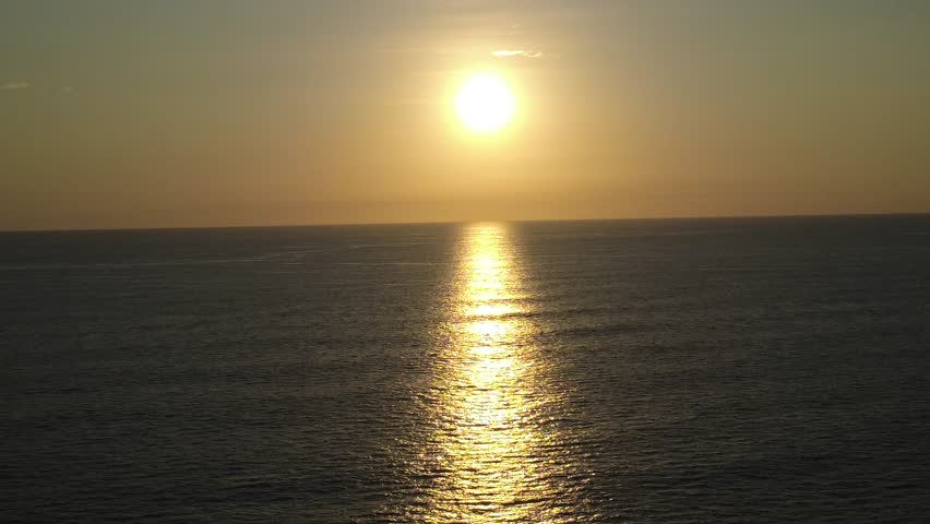 A peaceful aerial shot over the Pacific Ocean at sunset, filmed off the coast of Santa Teresa, Costa Rica.