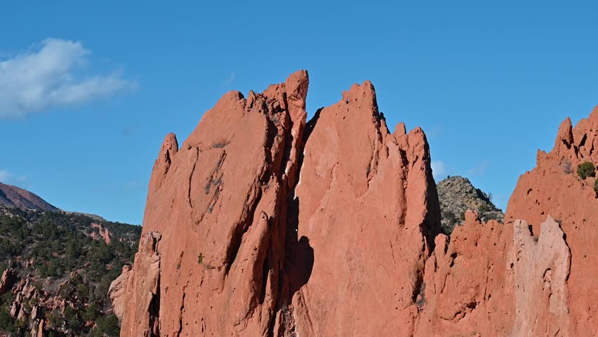 Crisp drone shot of rugged red rock formations at Garden of the Gods with blue skies and scattered clouds in Colorado Springs.