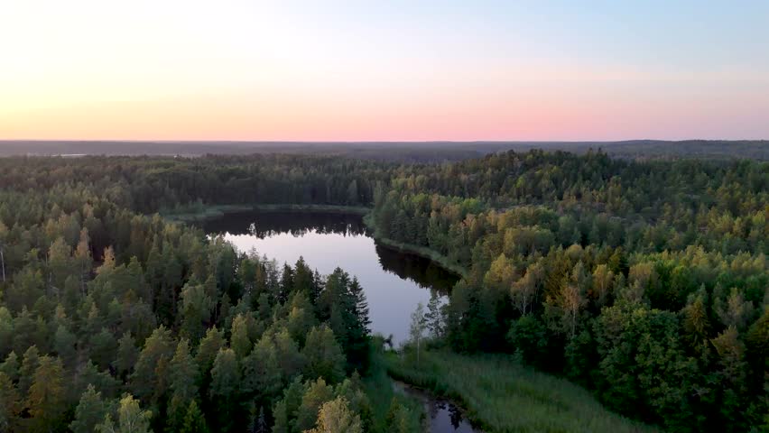 Slow-flying aerial drone view to a lake-and-forest scenery in Eastern Finland.
