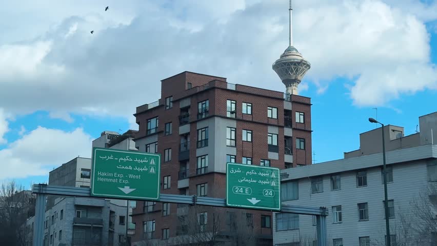 Tehran urban landscape in the city center Milad Tower and street transportation landmark sky daytime blue Iran architecture summer cityscape modern outdoors downtown highway traffic travel walking