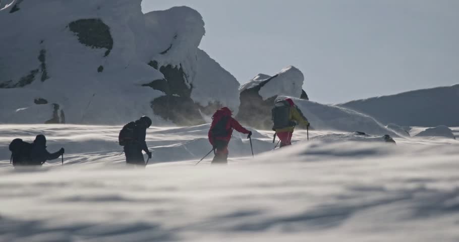 Group of Ski Tourers Hiking Up Snowy Mountain Slopes in Real-Time on a Bright Winter Day – Ski Touring Adventure in Deep Snowy Terrain