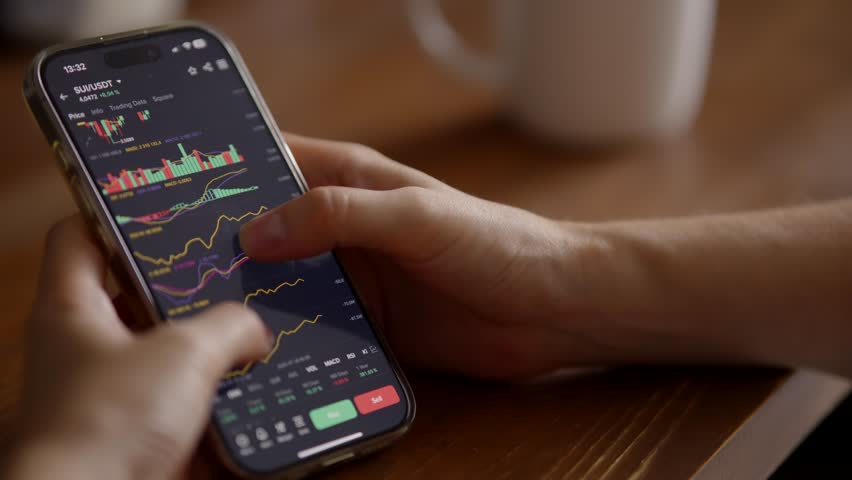Smartphone Displaying Cryptocurrency Charts. Trader Monitoring Financial Market Trends Crypto. Online Trading App, Digital Finance Stock Market Investing. Bitcoin Trading Cryptocurrency Exchange