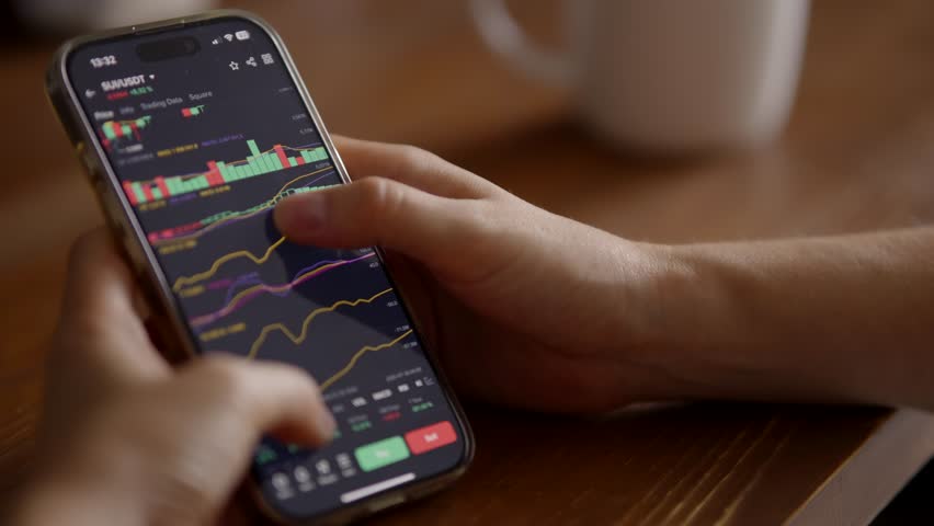 Smartphone Displaying Cryptocurrency Charts. Trader Monitoring Financial Market Trends Crypto. Online Trading App, Digital Finance Stock Market Investing. Bitcoin Trading Cryptocurrency Exchange