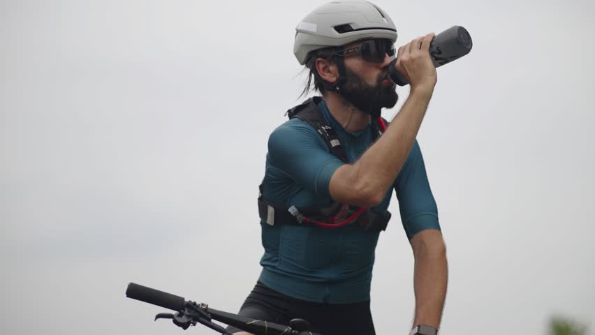 Cyclist Drinking Water Bottle. Taking Break During Ride. Hydration In Cycling. Healthy Habits And Fitness. Fitness And Endurance Sport Cycling. Mountain Bike Rider. Cyclist Cardio Exercise Hydrating 