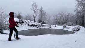 Woman wear red jacket hiking adventure in outdoor panoramic view of wonderful frozen lake winter forest countryside mountain snowfall nature activity scenic landscape peaceful in Iran freezing pond - Powered by Shutterstock - Get 15% off with code: PIKWIZARD15