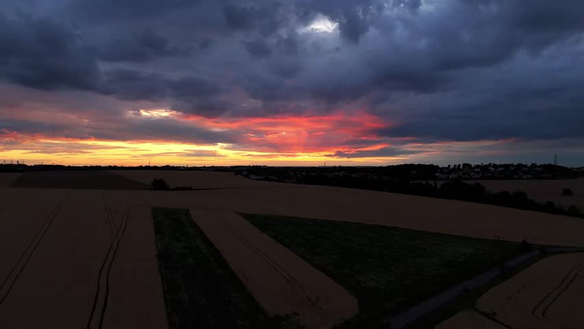 Drone footage of golden sunset over vast wheat fields, capturing warm light and peaceful rural landscape. Ideal for agriculture, nature, farming, and seasonal video projects.

