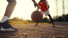 Active moment of streetball game, teens playing together outdoors in summer. Closeup view of bouncing ball and legs of players, basketball practicing in nature, team of future champions, slow motion - Powered by Shutterstock - Get 15% off with code: PIKWIZARD15