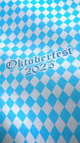 Vertical video animation of a Bavarian flag with the lettering Oktoberfest 2025 - Bavarian flag with diamond pattern - seamless loop.