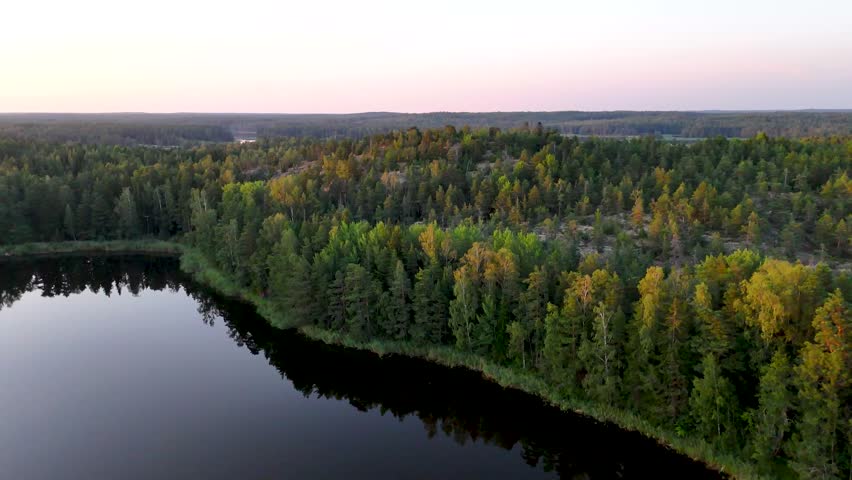 Finnish lake-and-forest landscape on a summer evening in an aerial drone view.