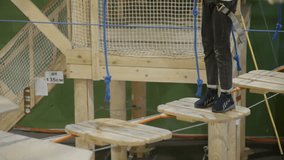 Young girl carefully crossing rope bridge in adventure park. Creative - Powered by Shutterstock - Get 15% off with code: PIKWIZARD15