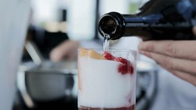 Bartender pouring champagne from bottle into glass with fresh fruits to make cocktail, slow motion, close-up - Powered by Shutterstock - Get 15% off with code: PIKWIZARD15