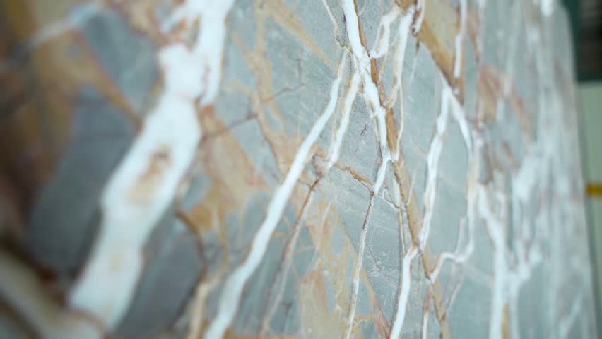 Close-up of natural marble slab with unique veins and patterns in brown, white, and gray. High-quality polished stone surface, perfect for interiors, tiles, countertops, and luxury design visuals.