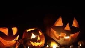 Spooky glowing Jack o lanterns with candle light on rustic table in dark autumn night. Happy Halloween! Scary atmospheric halloween carved pumpkins. Boo! Halloween footage. Trick or treat - Powered by Shutterstock - Get 15% off with code: PIKWIZARD15