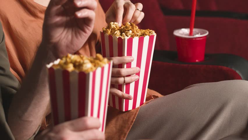 Close up hands man woman couple with popcorn, cinema movie theater with audience snack. Eating, film treat and people with premiere and food with crowd hungry with entertainment, relax and leisure