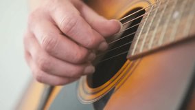 Close-up of a songwriter hand gently plucking the strings of an acoustic guitar in a calm, home environment. Creative moment of composing music. - Powered by Shutterstock - Get 15% off with code: PIKWIZARD15