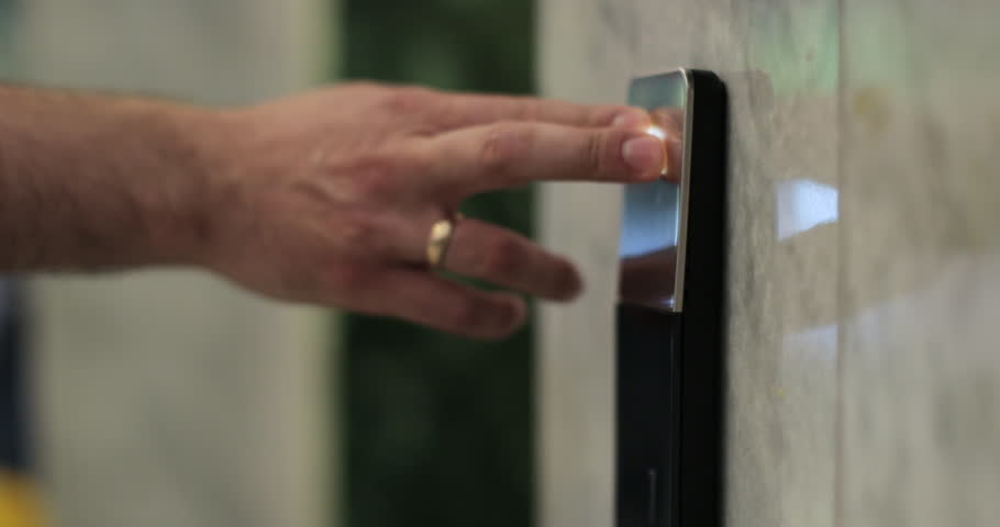 Man pushing elevator button in modern building or hotel. Male finger pressing lift button.