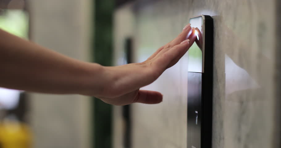 Woman presses the elevator button in office center or hotel. Elevator door control concept.