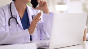 Asian adult doctor consults patients remotely using digital technology. Expert woman offers medical advice from modern clinic workplace. - Powered by Shutterstock - Get 15% off with code: PIKWIZARD15