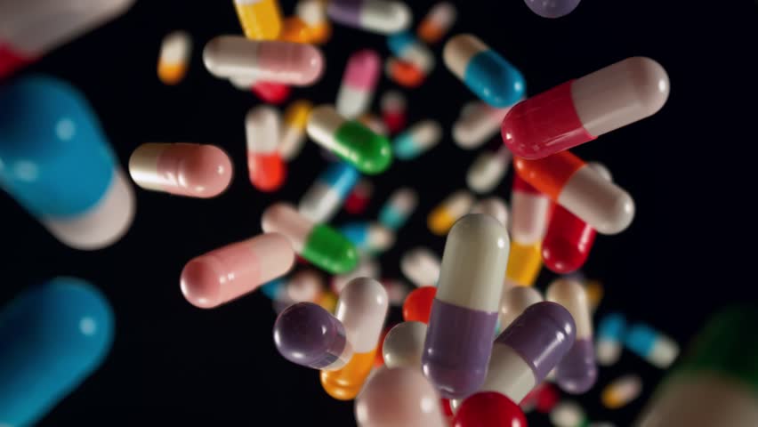 Super Slow Motion of Falling Colorful Pills on Black Background at 1000fps.