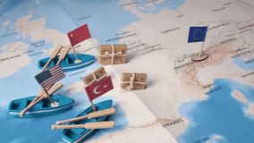 Miniature boats with USA, China, Turkey flags and EU flag and small parcels positioned on a world map, illustrating the complexities of global trade, import, and export logistics - Powered by Shutterstock - Get 15% off with code: PIKWIZARD15