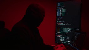 Hacker in balaclava with an obscured face is stealing data, representing cybercrime, hacking, dark web activity, and online security threats. Cyber Security concept.
 - Powered by Shutterstock - Get 15% off with code: PIKWIZARD15