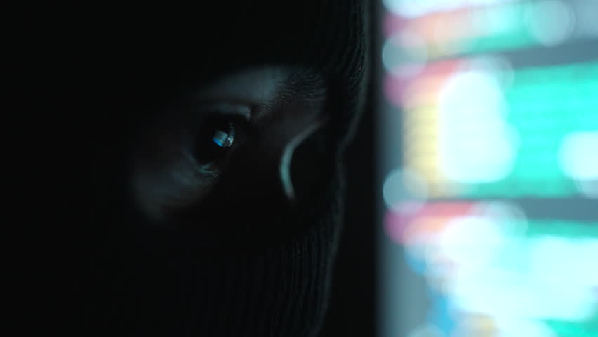 Close-up Thief Hacker in balaclava with an obscured face is stealing data, representing cybercrime, hacking, dark web activity, and online security threats in dark room. Cyber Security concept.
 - Powered by Shutterstock - Get 15% off with code: PIKWIZARD15