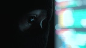Close-up Thief Hacker in balaclava with an obscured face is stealing data, representing cybercrime, hacking, dark web activity, and online security threats in dark room. Cyber Security concept.
 - Powered by Shutterstock - Get 15% off with code: PIKWIZARD15