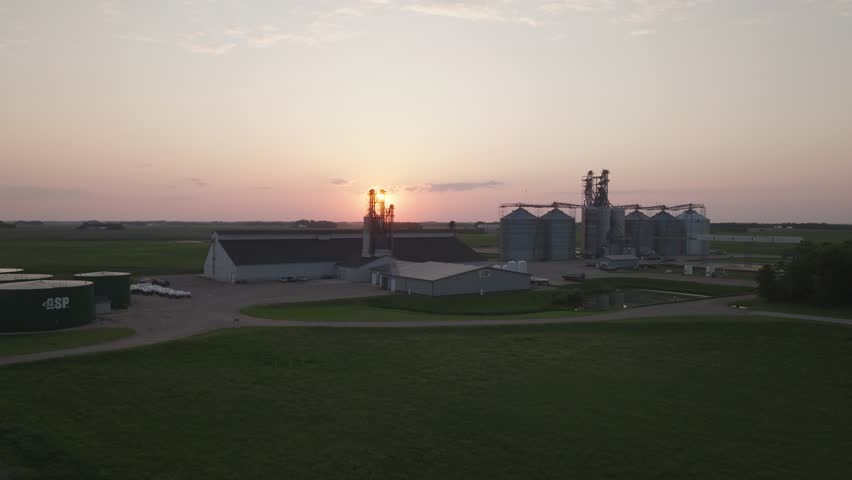Grain Silos And Barns On A Rural Farm At Sunset. - aerial shot