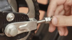 Close up to a hand tightening a nut and bolt screw in the process of tuning a motorcycle part - Powered by Shutterstock - Get 15% off with code: PIKWIZARD15