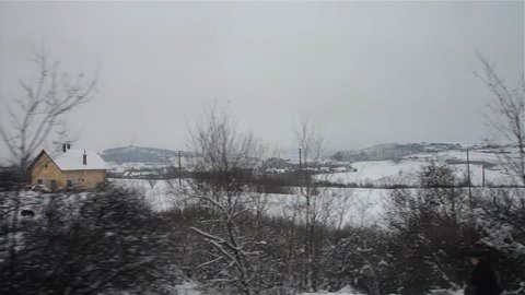 View captured on the window of a train over snowy fields
