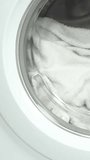 Washing machine washes white clothing and sheets. Cylinder spinning. Nobody. Vertical footage - Powered by Shutterstock - Get 15% off with code: PIKWIZARD15