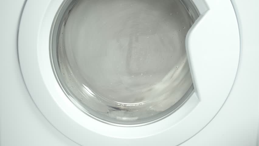 Washing machine washes white clothing and sheets. Cylinder spinning. Nobody