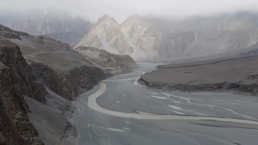 Aerial View of a Serene River Valley in Pakistan, Highlighting Majestic Mountains and a Winding River Path