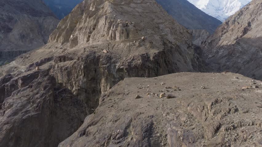 Aerial View of a Remote Mountainous Region in Pakistan, Highlighting Snow-Capped Peaks and Barren Terrain