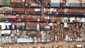 This high-angle shot captures a vibrant African market with tightly packed stalls featuring rusty metal roofs, contrasted by large piles of lumber and busy pedestrian walkways. - Powered by Shutterstock - Get 15% off with code: PIKWIZARD15