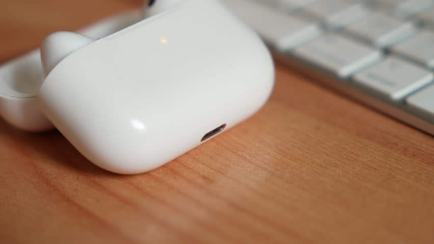 Close-up of a wireless earbud being placed into its charging case.