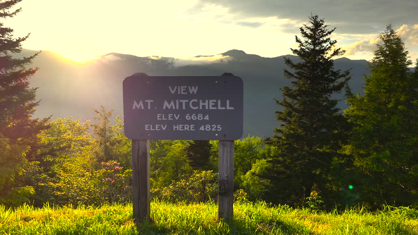 Road trip travel in Appalachian mountains at sunset. Mt. Mitchell Overlook on parkway and woods nature in summer season. Colorful forest in North Carolina.