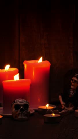 Skull and candles on wooden background. Jack-o-lantern on black background. Vertical footage