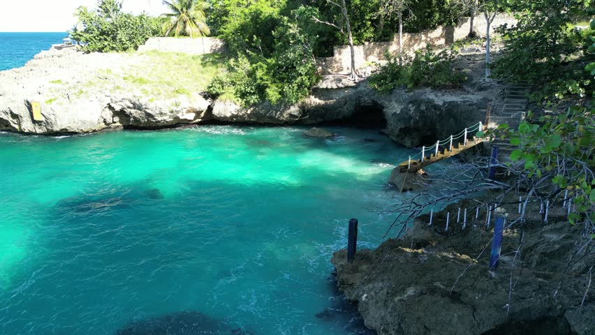 Stunning drone video of the natural pool in Río San Juan, Dominican Republic.Bright turquoise water, rocky coast, and green surroundings under sunny skies.Great for travel, nature, and adventure films