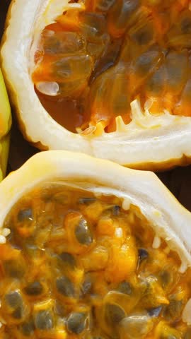 Passion fruit background with half cut chinola. A lot of sliced maracuja. Tropical fruits backdrop. Vertical footage