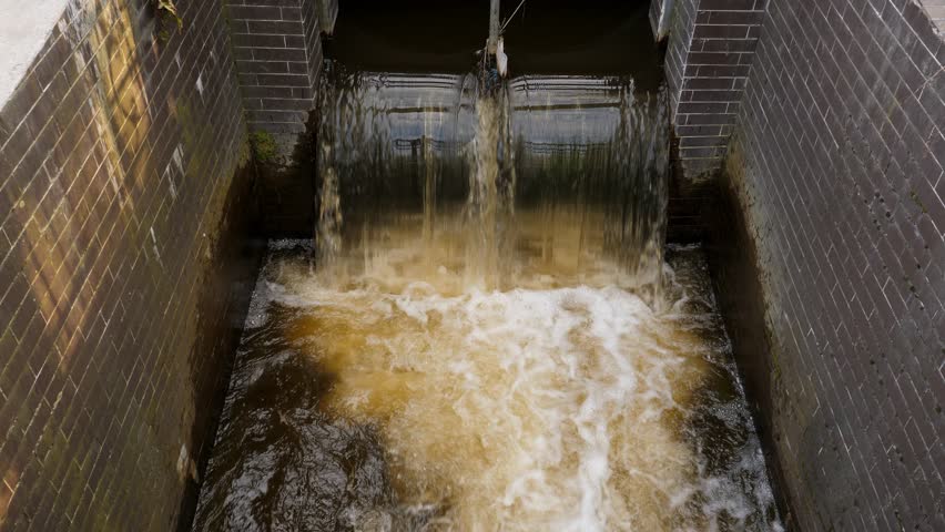 Dirty water flow from pipe. Water discharge. Ecology and environment pollution concept. Outdoors