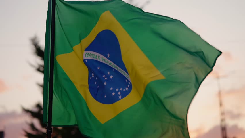 Brazilian Flag Blowing In The Wind At Sunset