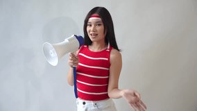Excited young Asian woman wearing a white t-shirt and red sweater shouts into a megaphone announcing a discount, isolated on a white background. Indonesian Independence Day concept. - Powered by Shutterstock - Get 15% off with code: PIKWIZARD15