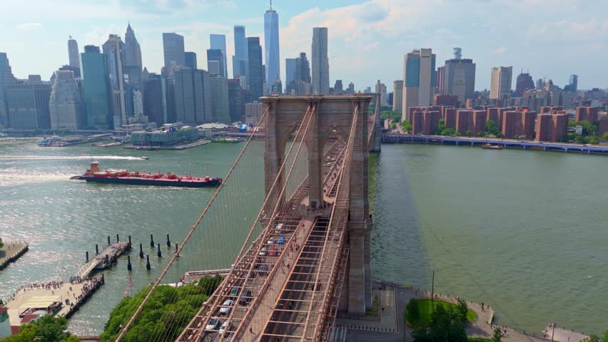 Brooklyn Bridge with traffic, lower Manhattan skyline with One World Trade Center and East River in background, New York City, USA. Aerial drone