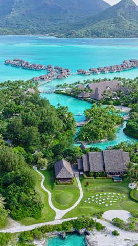 Bora Bora, French Polynesia. Vertical Drone Shot of Luxury Resort, Overwater Bungalows and Main Island With Volcanic Hills