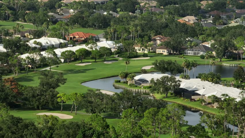 Golf course with palm trees in luxury neighborhood of Bradenton, Florida. Aerial wide shot. Sunny day with villas and mansions.