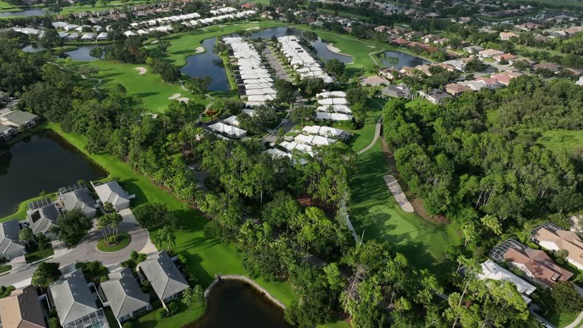 Luxury and exclusive neighborhood in Bradenton with private golf course and lake. Sunny summer day in Florida. Upper class villas and mansion in USA. Aerial wide shot. Well-kept landscape.