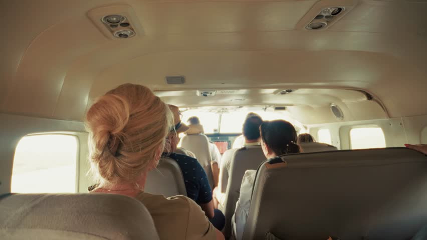 Passengers In Small Airplane. Group Of People Traveling On Private Jet. Aviation And Travel. Holiday Transportation, Flying To Destination. Business Leisure Trip. Air Travel Small Aircraft. In-Flight