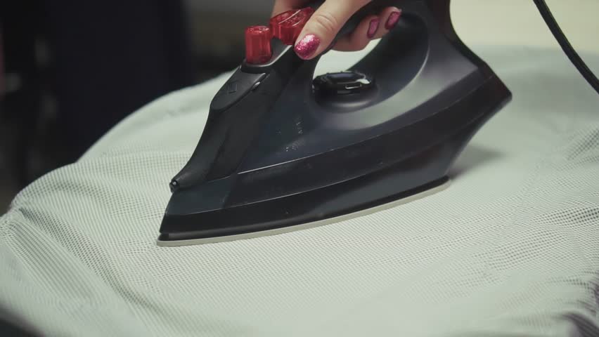Ironing Shirt On Ironing Board. Household Chore Daily Routine. Domestic Life Housekeeping And Cleaning. Wrinkle-Free Clothes Home Task. Laundry Day. Ironing Process Housewife At Work. Neat And Tidy